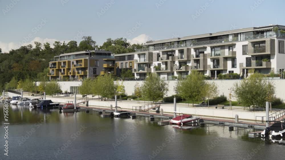 Apartment buildings and a boat dock on a river shore on a sunny day Apartment buildings and a boat dock on a river shore on a sunny day