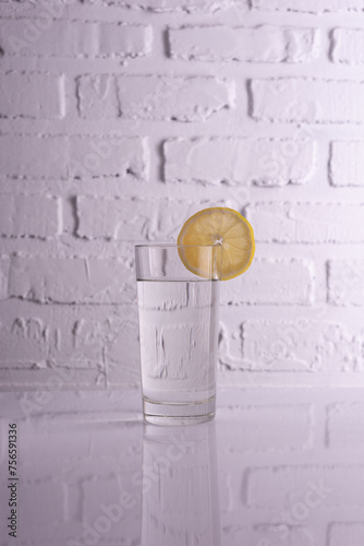 glass of water with lemon on a white background