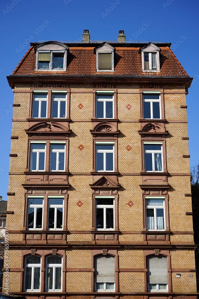 Saniertes altes Wohnhaus mit Fassade in Beige, Braun und Naturfarben vor blauem Himmel im Sonnenschein an der Walter-Kolb-Straße im Stadtteil Sachsenhausen in Frankfurt am Main in Hessen