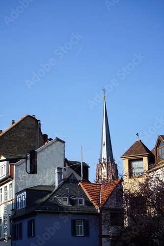 Blick von der Schulstraße über schöne Altbauten auf den spitzen Kirchturm der Dreikönigskirche vor blauem Himmel im Sonnenschein im Stadtteil Sachsenhausen in Frankfurt am Main in Hessen
