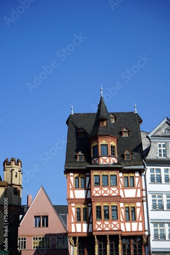 Restaurierte Fassaden von traditionellen Fachwerkhäusern vor blauem Himmel im Sonnenschein in der Altstadt am Römerberg in Frankfurt am Main in Hessen