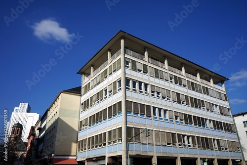 Denkmalgeschütztes Bürohaus der Fünfzigerjahre und der Nachkriegszeit mit Sanierter Fassade in Pastellfarben vor blauem Himmel im Sonnenschein in der Berliner Straße in der City von Frankfurt am Main