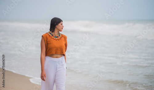Mujer despreocupada caminando en un día de verano en la playa photo
