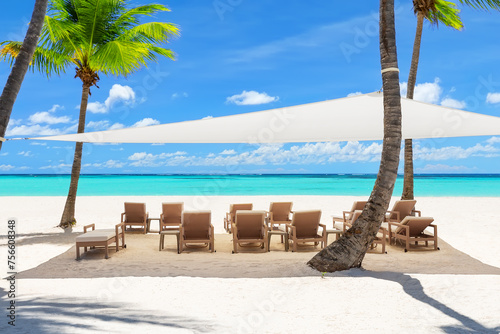 Fototapeta Naklejka Na Ścianę i Meble -  Beach chairs under a canopy on a beautiful white sand beach in Punta Cana, Dominican Republic.