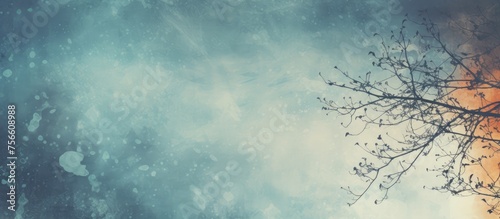 A bare tree silhouette stands out against a backdrop of a cloudy sky, showcasing the natural landscape with cumulus clouds and an electric blue sky pattern