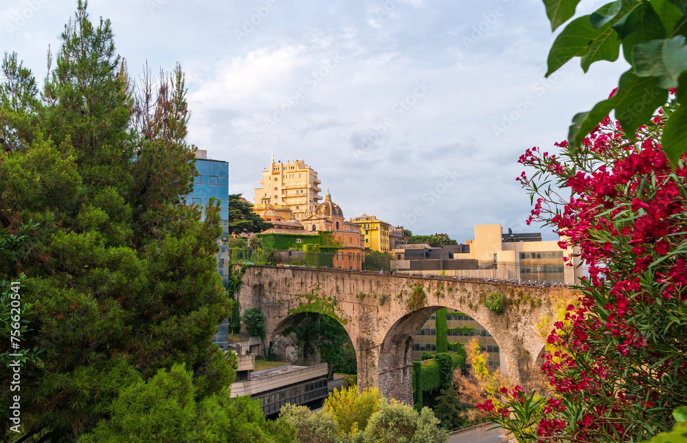 Cityscape of Genoa overlooking the Viaduct Via Eugenia Ravasco with oleander flowers in the foreground, Italy.