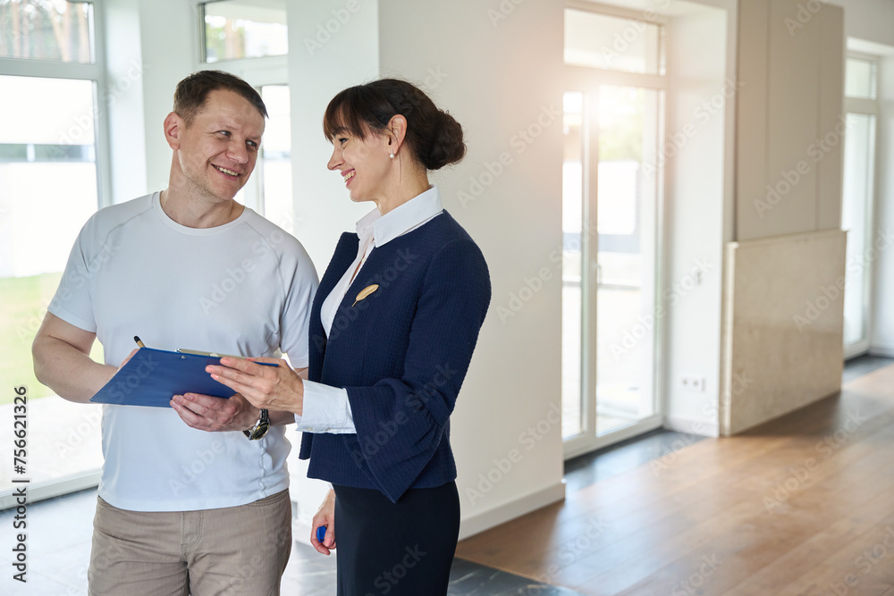 Fototapeta premium Satisfied buyer signs documents for purchasing a house