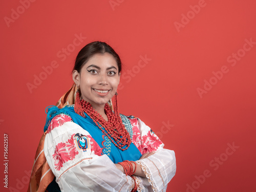 hispanic girl dressed in cayambe costume happy on red background photo