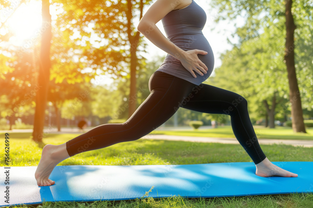 Fototapeta premium Pregnant woman exercising in the park in preparation for motherhood