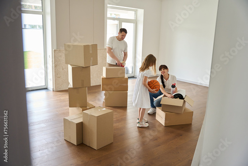 Family unpacking things in a new house © Svitlana