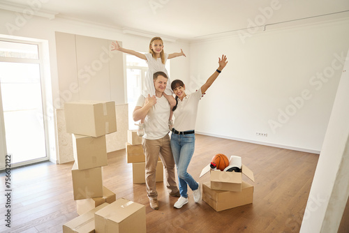 Happy family in the middle of a spacious empty room