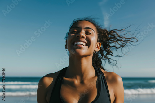Smiling  happy woman jogging at the beach in the early evening sun