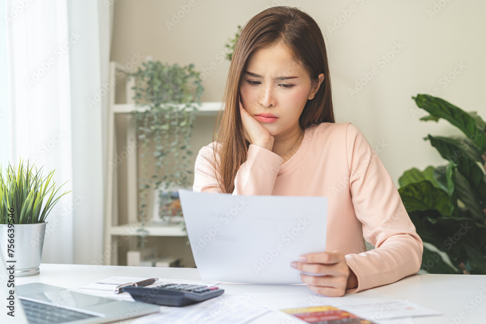 Business financial concept, stressed asian young woman hand checking list statement of credit card for calculate accounting expense, tax for payment on due deadline, trying to find money to pay debt. Business financial concept, stressed asian young woman hand checking list statement of credit card for calculate accounting expense, tax for payment on due deadline, trying to find money to pay debt.