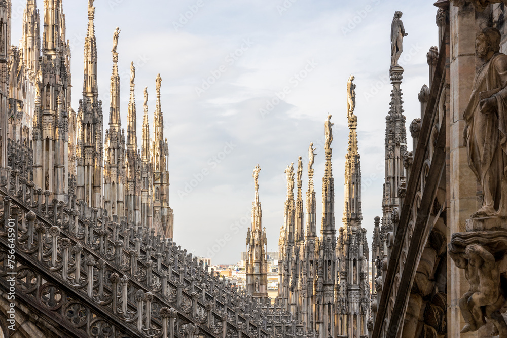 The famous Milan Cathedral (Duomo di Milano) on the Piazza del Duomo in Milan, Italy. Details on the roof The famous Milan Cathedral (Duomo di Milano) on the Piazza del Duomo in Milan, Italy. Details on the roof