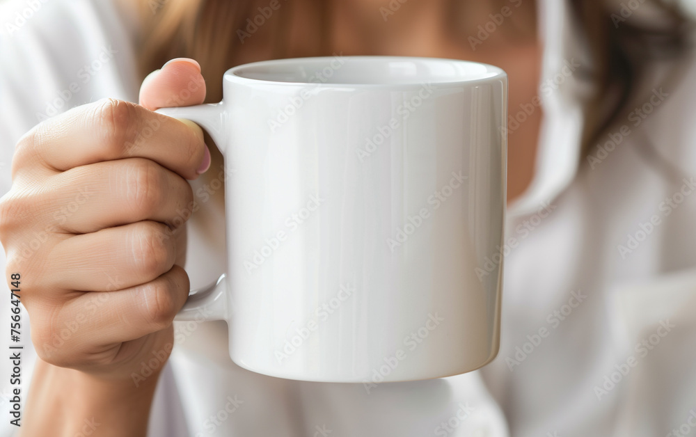 Close-up of a white ceramic mug held in a woman's hand Close-up of a white ceramic mug held in a woman's hand