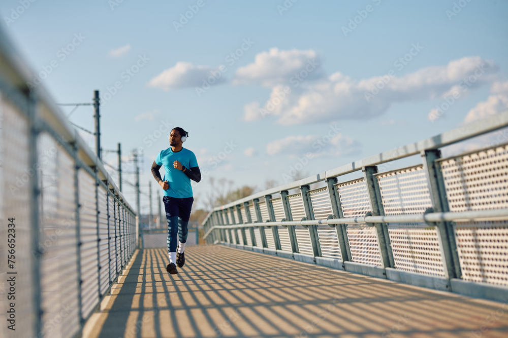 Black athletic man jogging outdoors.