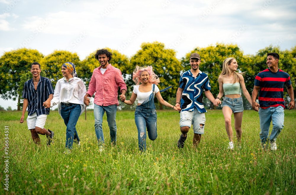 Obraz premium Group of multiethnic teenagers spending time outdoor on a picnic at the park