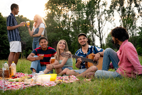 Group of multiethnic teenagers spending time outdoor on a picnic at the park
