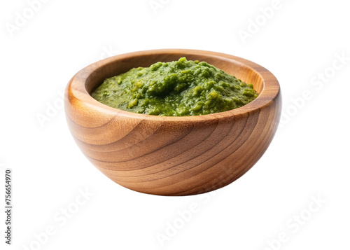 Pesto sauce in a wooden bowl isolated on a transparent background.