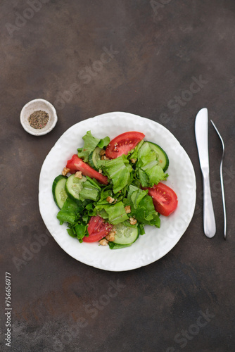  Vegetable salad - tomatoes, cucumbers, salad on white plate on dark brown background. Healthy Eating. Diet Concept. A Healthy Way Of Life. To Cook At Home. For Cooking. 