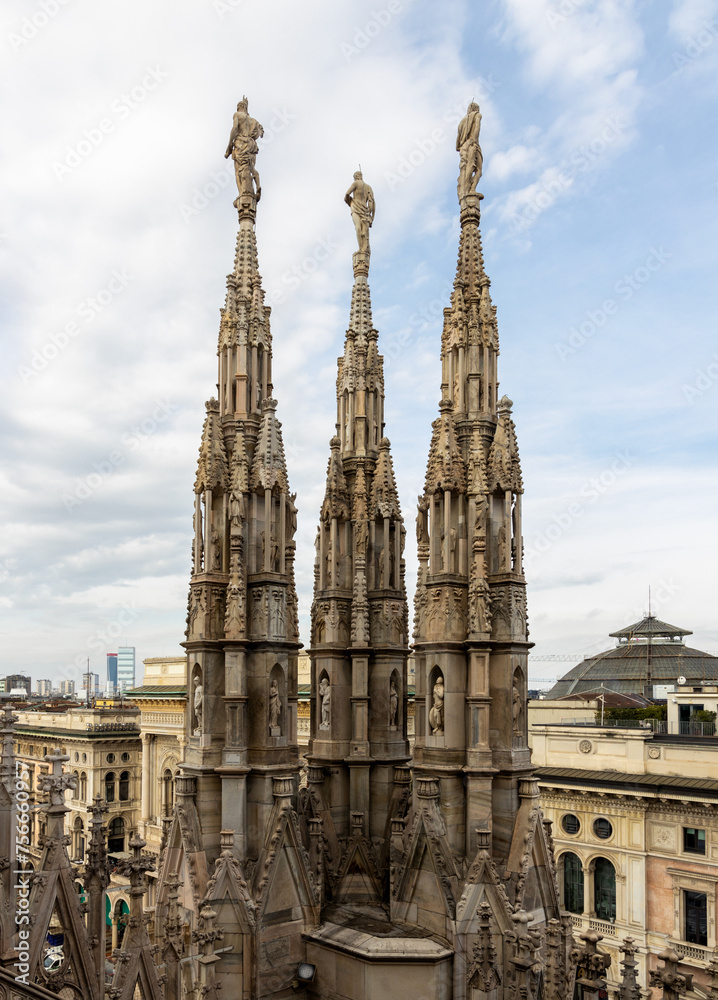 The famous Milan Cathedral (Duomo di Milano) on the Piazza del Duomo in Milan, Italy. Details on the roof The famous Milan Cathedral (Duomo di Milano) on the Piazza del Duomo in Milan, Italy. Details on the roof
