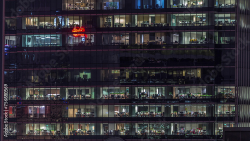 Modern office building with big windows at night timelapse, in windows light shines