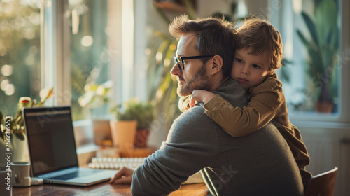 Father working from home with his child near his shoulder