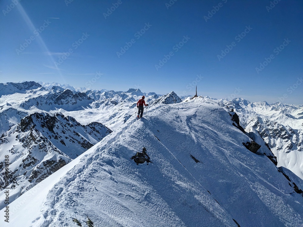 Mountaineers on the summit of the Flüela Wisshorn above Davos. Breathtaking views of the beautiful Swiss mountains.Ski mountaineering in winter. Summit ridge with snow. Enjoy life at the highest point