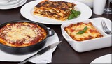 A table with a variety of lasagna dishes, including a black pan lasagna