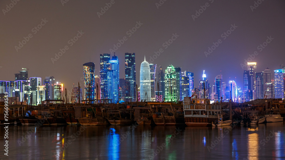 Fototapeta premium A panoramic view of the old dhow harbour night timelapse in Doha, Qatar, with the West Bay skyline in the background.