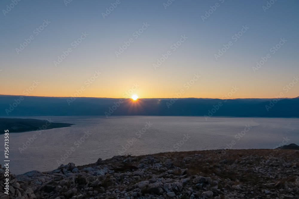 Fototapeta premium Panoramic view of sunrise over karst mountains along idyllic hiking trail near coastal town Baska, Krk Otok, Primorje-Gorski Kotar, Croatia, Europe. Majestic coastline Mediterranean Adriatic Sea