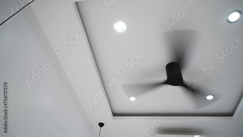 The ceiling fan in the hotel room is turned on