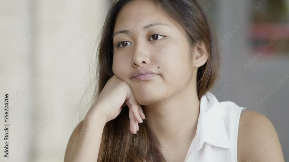 thoughtful Asian young woman sitting alone lost in her thoughts thoughtful Asian young woman sitting alone lost in her thoughts