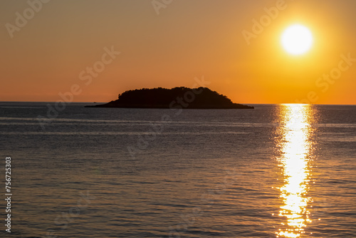 Watching dramatic sunset at coastal village Funtana  Istria  Croatia  EU. Silhouette of remote tropical island. Calm sea surface reflects vibrant colors of sky. Vacation at Adriatic Mediterranean Sea