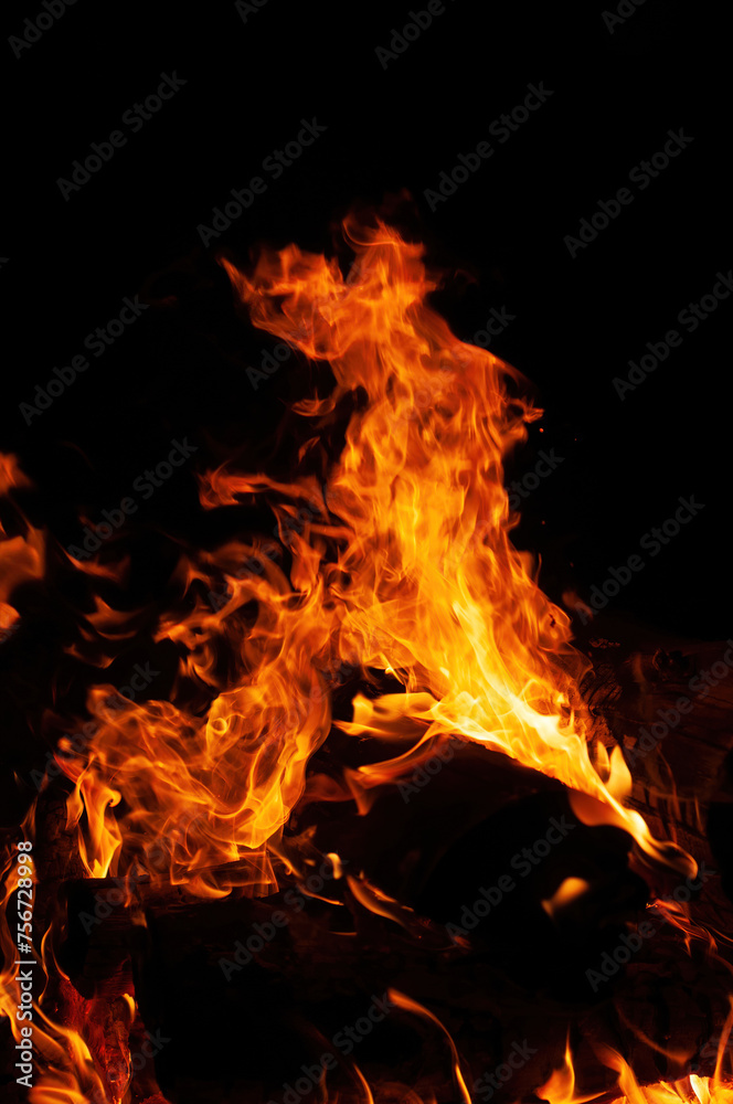 A mesmerizing close up of bonfire in nature, with flames dancing against black background. heat and flickering flames create captivating event, reminiscent of cozy fireplace or campfire A mesmerizing close up of bonfire in nature, with flames dancing against black background. heat and flickering flames create captivating event, reminiscent of cozy fireplace or campfire