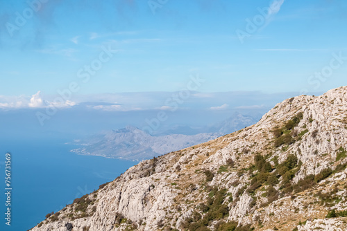 Panoramic aerial view of the Makarska Riviera seen from skywalk in Biokovo nature park, Dalmatia, Croatia. Majestic karst coastline of Adriatic Mediterranean sea in summer. Tranquil serene atmosphere photo