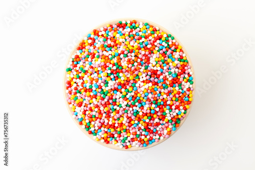 Confectionery sprinkles in bowl on white background. Decoration for cake and bakery. Top view