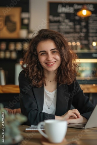 A woman sitting at a table with a laptop, suitable for business concepts