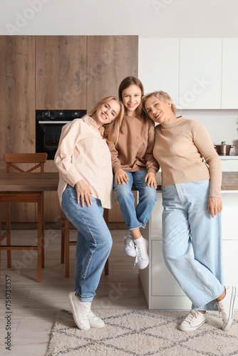 Little girl with her mom and grandmother smiling in kitchen