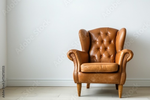 A brown leather chair is positioned in front of a white wall.