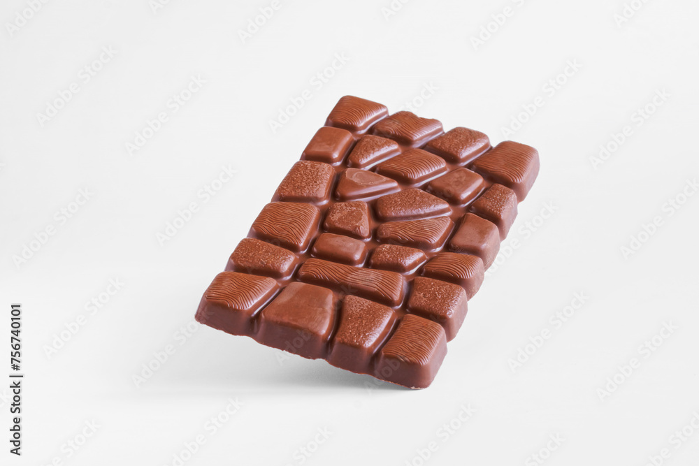 Rectangular bar of chocolate falling on white surface. Photo. Natural lighting Rectangular bar of chocolate falling on white surface. Photo. Natural lighting