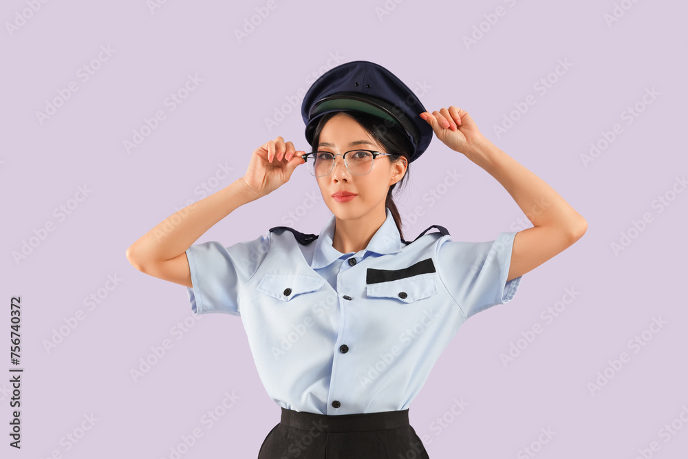 Young Asian postwoman wearing glasses on lilac background