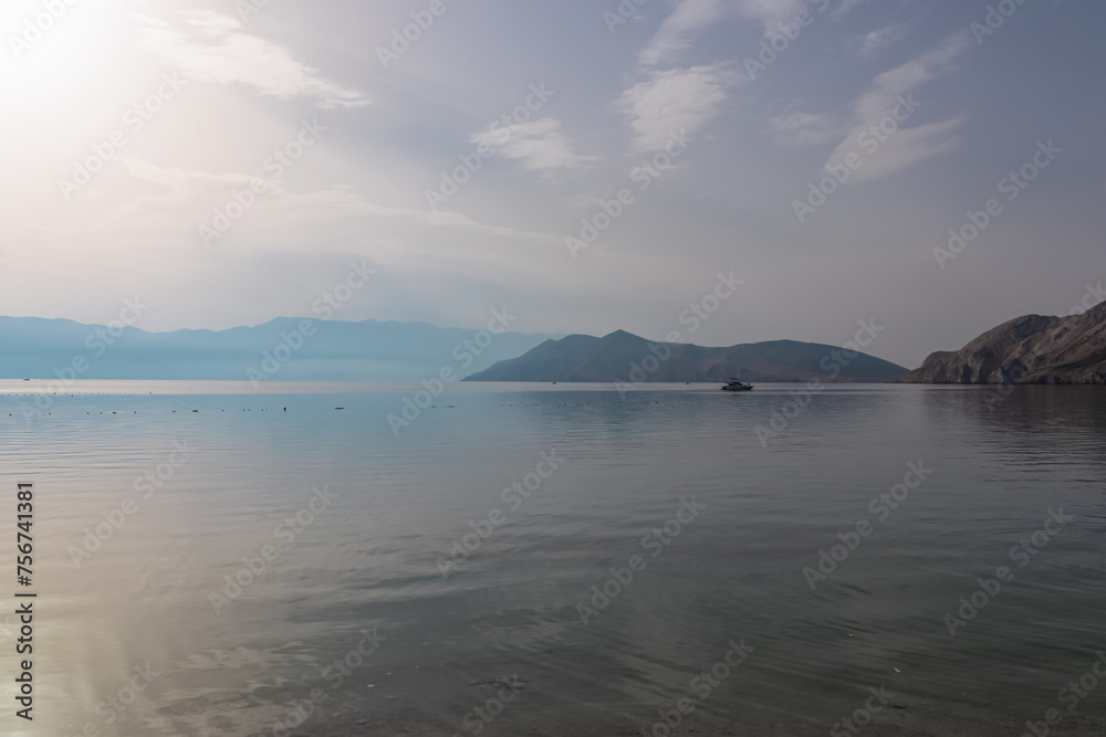 Scenic sunrise view of deserted island Prvic seen from beach in coastal town Baska, Krk Otok, Primorje-Gorski Kotar, Croatia, Europe. Majestic coastline of Mediterranean Adriatic Sea in Kvarner bay