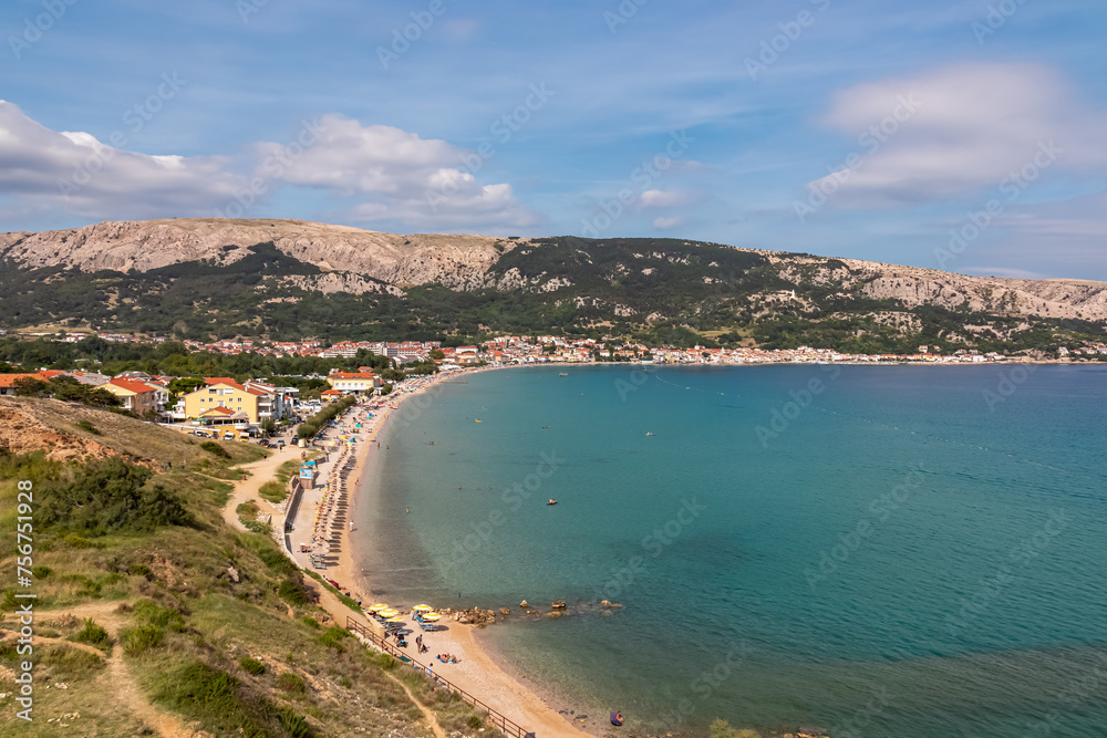 Panoramic aerial view of idyllic beach in coastal town Baska, Krk Island, Primorje-Gorski Kotar, Croatia, Europe. Vacation in turquoise water bay. Majestic coastline of Mediterranean Adriatic Sea
