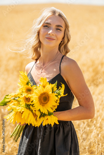 Young beautiful woman with a bouquet of sunflowers