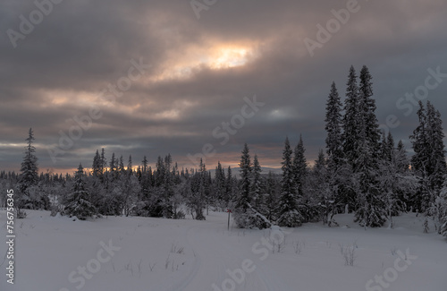 Sunrise breaking through clouds above a nordic ski track in Sweden
