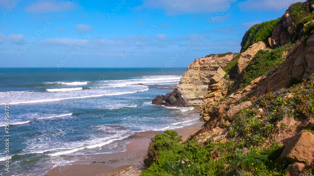 Panoramic view of idyllic landscape at the seaside in coastal village Ericeira, Portugal, Europe. Looking at majestic Atlantic Ocean. Serene tranquil vacation atmosphere. Calm waves arrive at seashore