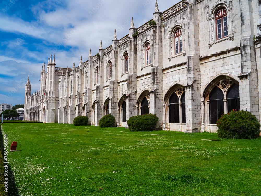 Scenic view of Mosteiro or monastery dos Jeronimos in city of Lisbon, Portugal. Displaying Manueline architecture surrounded by idyllic Praca do Imperio gardens. Tourist travel destination