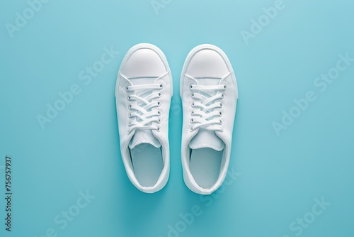 Top view of pair of modern sport shoes on blue background