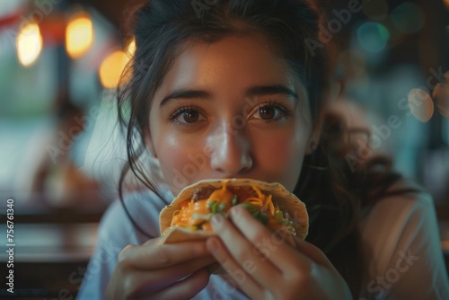 A woman enjoying a taco in a restaurant, perfect for food-related projects
